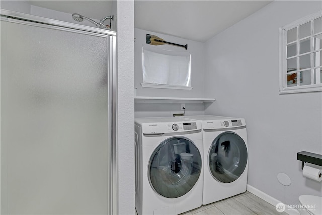 laundry area featuring baseboards, washing machine and dryer, and laundry area