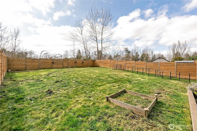 view of yard with a vegetable garden and a fenced backyard