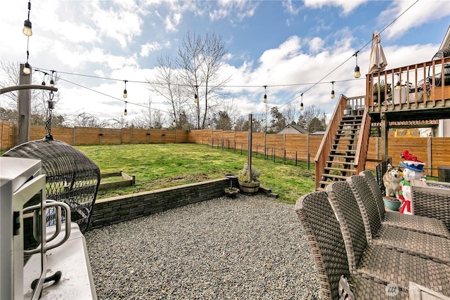 view of yard with a deck, a fenced backyard, and stairs