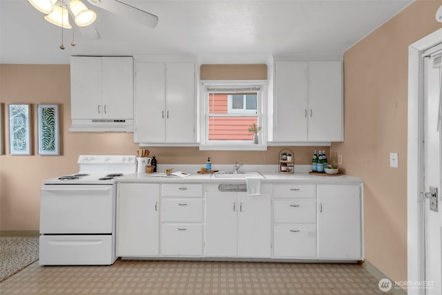 kitchen with baseboards, under cabinet range hood, light floors, light countertops, and electric range