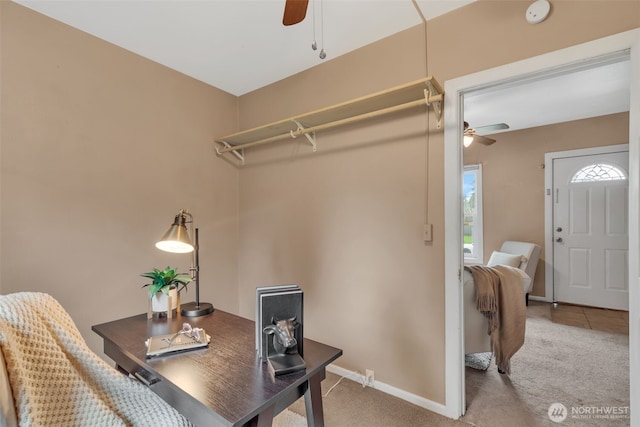 home office featuring light carpet, baseboards, and ceiling fan