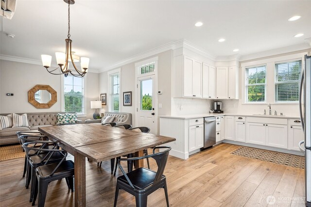 kitchen with plenty of natural light, light wood finished floors, and ornamental molding