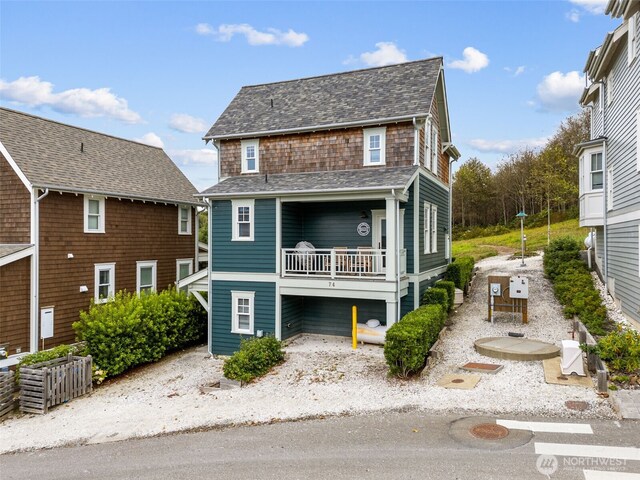 view of front of home featuring a balcony and a shingled roof