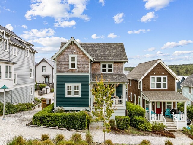 shingle-style home featuring a porch and a shingled roof