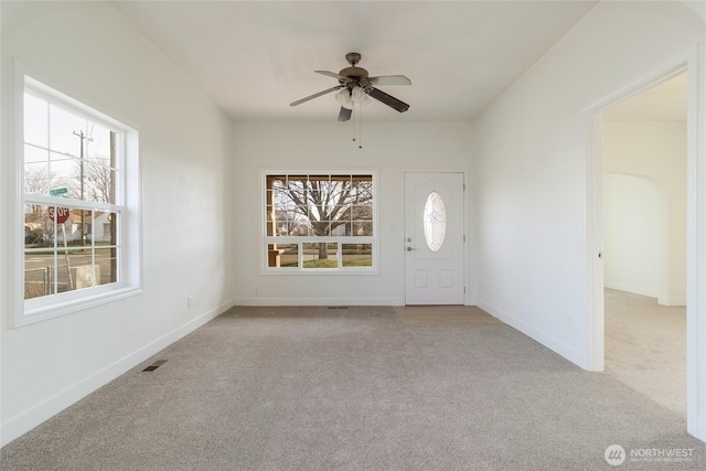 entryway with carpet, a healthy amount of sunlight, visible vents, and baseboards