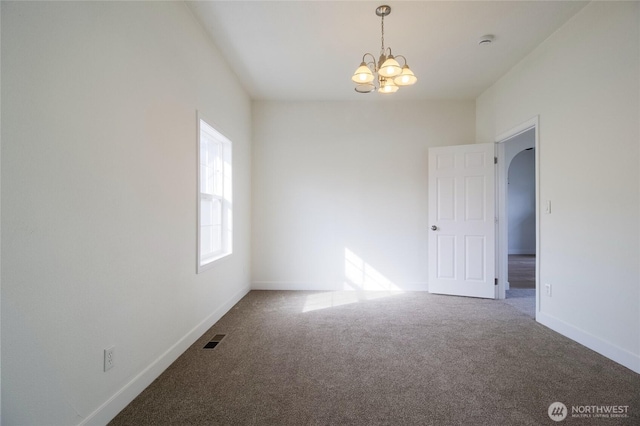 unfurnished room featuring visible vents, baseboards, carpet, and a chandelier