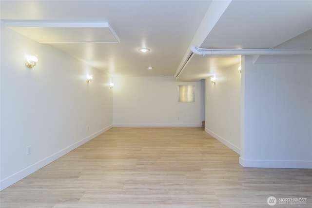 basement featuring baseboards and light wood finished floors