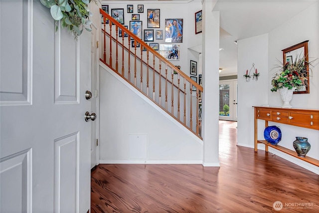 foyer with stairway, baseboards, and wood finished floors