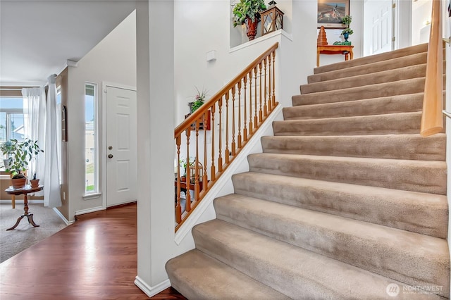 foyer entrance featuring stairway, baseboards, and wood finished floors