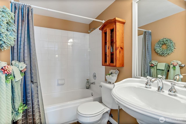 bathroom with toilet, shower / bath combo, and a sink