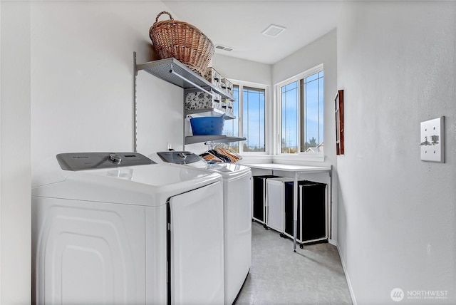 clothes washing area featuring visible vents, baseboards, separate washer and dryer, and laundry area