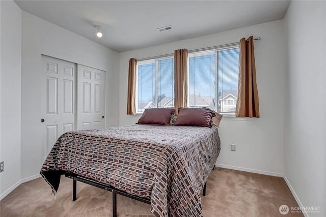 carpeted bedroom featuring a closet, visible vents, and baseboards