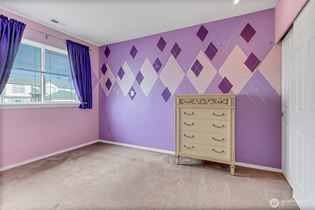 unfurnished bedroom featuring a closet, baseboards, carpet, and an accent wall