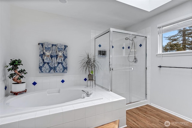 bathroom featuring wood finished floors, a garden tub, and a stall shower