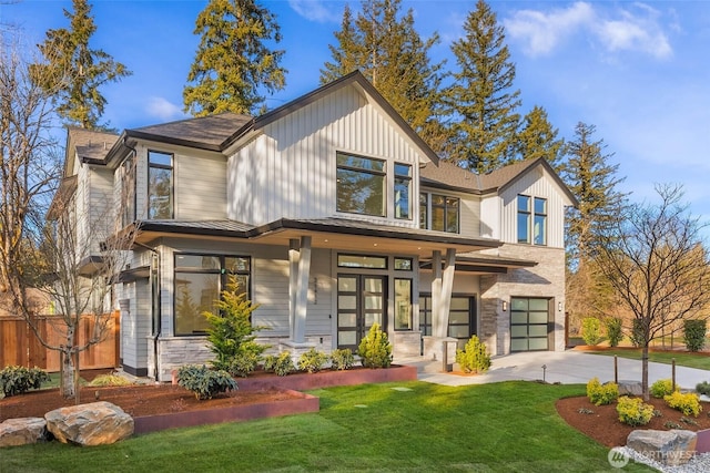 view of front of property with an attached garage, concrete driveway, a front yard, and fence