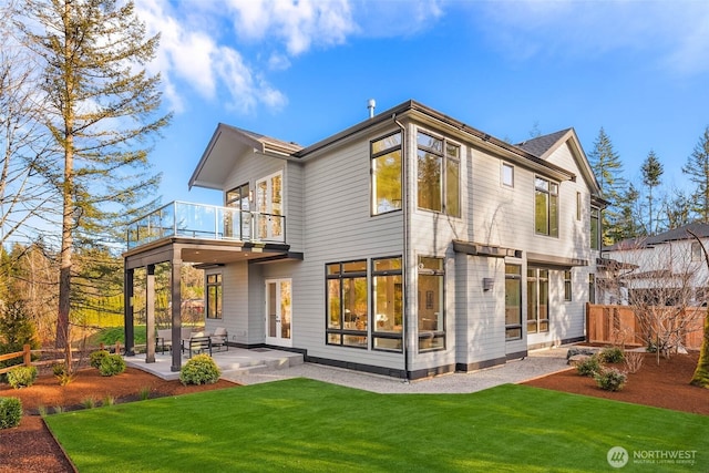 back of property with a patio, a balcony, a lawn, and fence