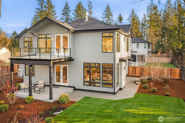 rear view of house with a patio area, french doors, a yard, and fence