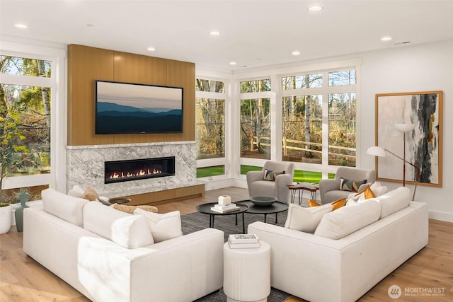 living area with a fireplace, recessed lighting, and wood finished floors