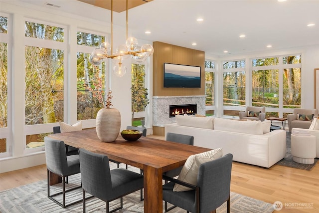 sunroom featuring visible vents and a warm lit fireplace