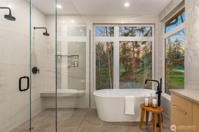 bathroom featuring a shower stall, a freestanding tub, and tile walls