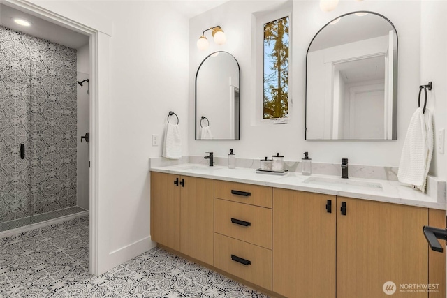 full bathroom with tile patterned flooring, double vanity, walk in shower, and a sink