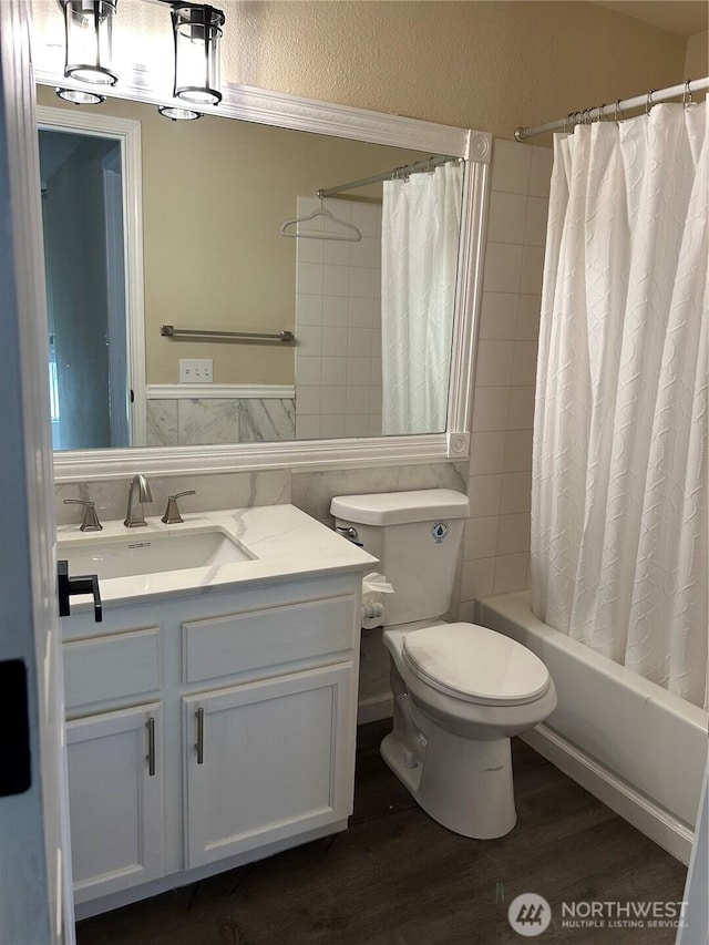 bathroom with vanity, shower / bathtub combination with curtain, toilet, and wood finished floors