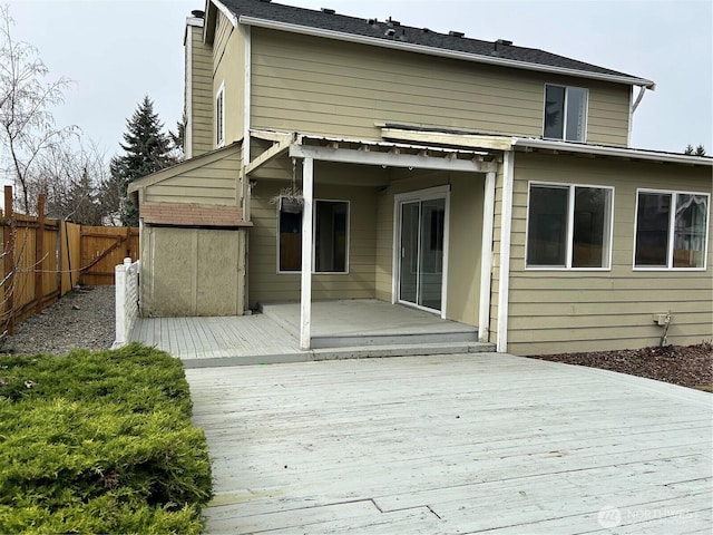 rear view of property featuring a deck and a fenced backyard