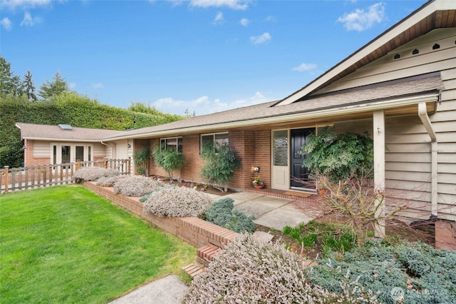 exterior space featuring brick siding and a front lawn