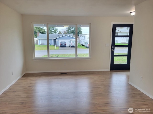 interior space with visible vents, baseboards, and wood finished floors