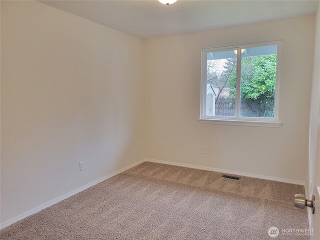 carpeted empty room featuring visible vents and baseboards