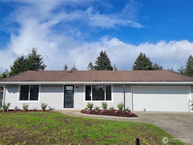 ranch-style house with a front yard, concrete driveway, and a garage