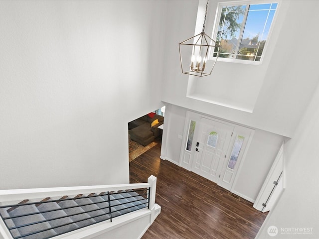 foyer featuring an inviting chandelier, wood finished floors, and baseboards