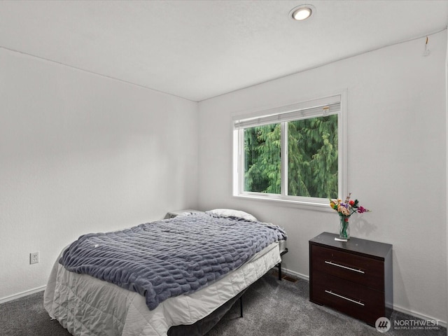 bedroom featuring baseboards and dark carpet