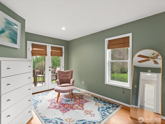 sitting room featuring plenty of natural light, french doors, light wood-style floors, and baseboards