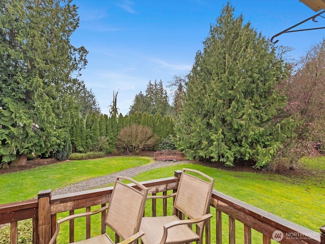 wooden deck featuring a lawn