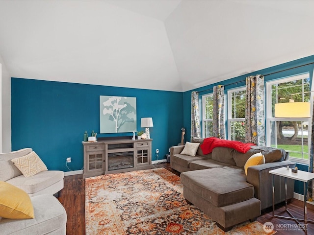 living room with vaulted ceiling, wood finished floors, a healthy amount of sunlight, and baseboards