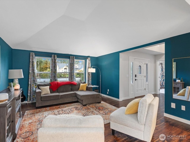 living area with high vaulted ceiling, baseboards, and wood finished floors