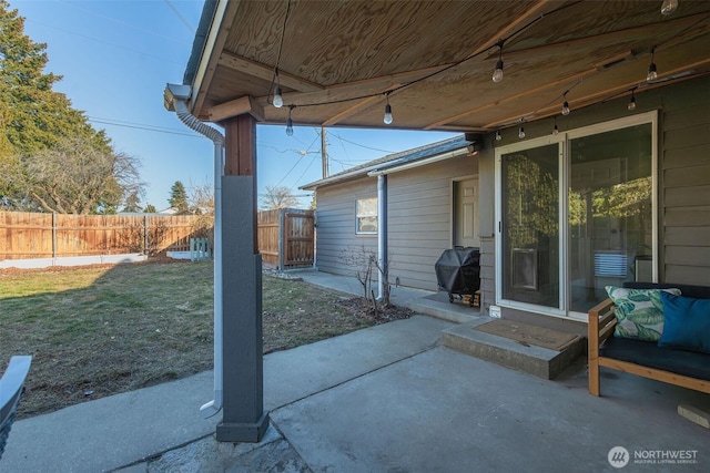 view of patio featuring fence and a grill