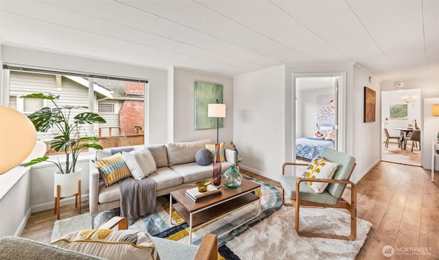 living room featuring a wealth of natural light, baseboards, and light wood-style flooring