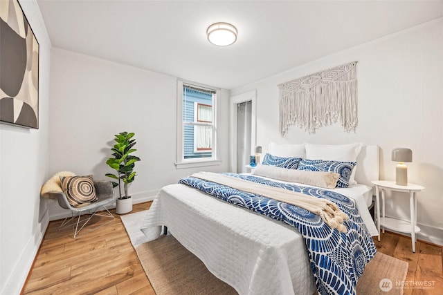 bedroom with baseboards and hardwood / wood-style flooring