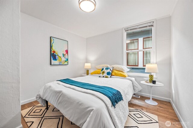 bedroom with baseboards and wood finished floors