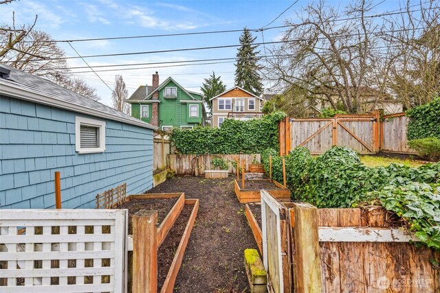 view of yard featuring fence, a vegetable garden, and a gate