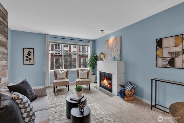 living room with a fireplace with flush hearth, baseboards, and carpet floors