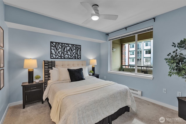 carpeted bedroom with baseboard heating, ceiling fan, and baseboards