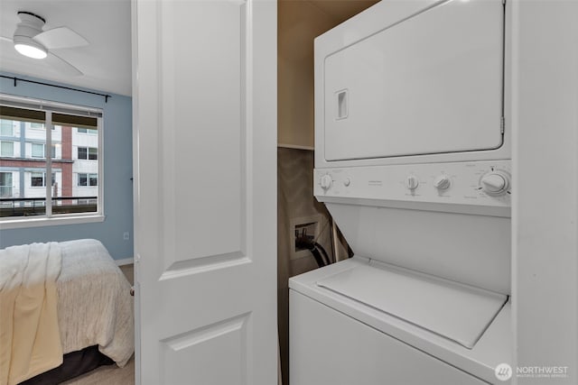 laundry area featuring stacked washer / dryer, laundry area, and a ceiling fan