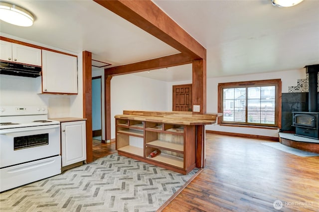 kitchen featuring wooden counters, under cabinet range hood, electric stove, a wood stove, and white cabinetry