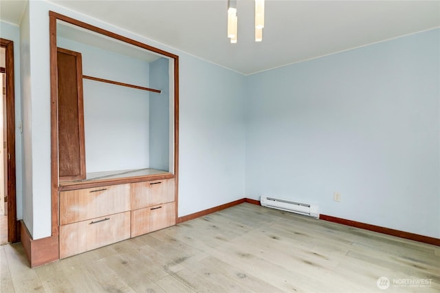 unfurnished bedroom featuring light wood-type flooring, a baseboard radiator, and baseboards