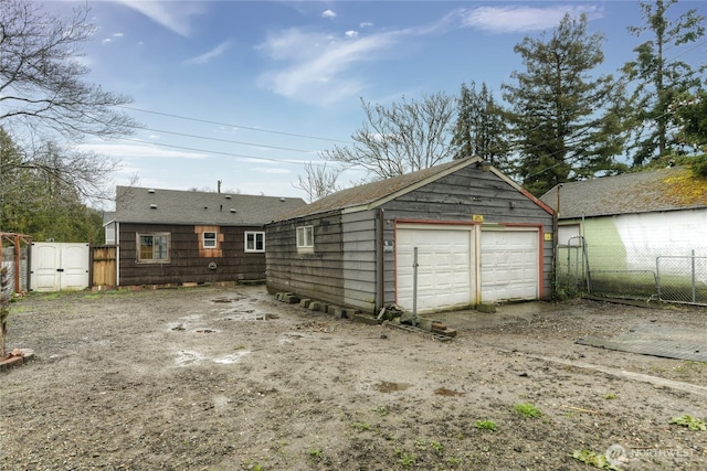 garage featuring fence and a gate