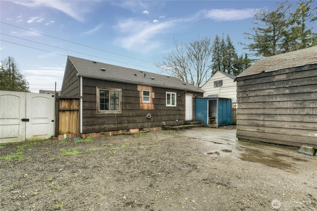 rear view of house featuring fence and a gate