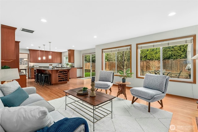 living area featuring recessed lighting, visible vents, baseboards, and light wood-style floors